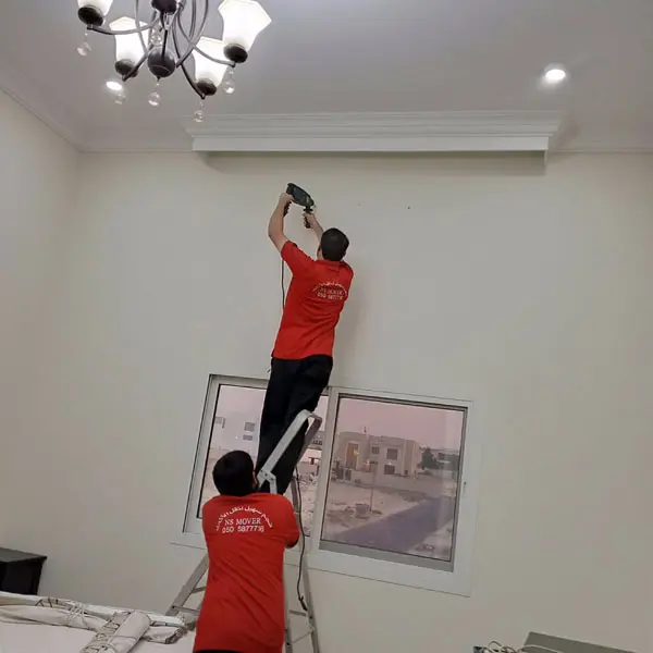 Movers and packers in Abu Dhabi installing curtains at new home