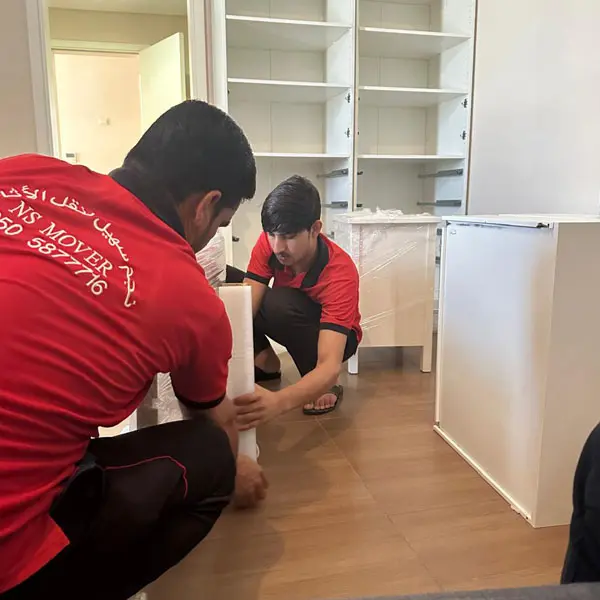 Movers in Abu Dhabi packing furniture with protective materials
